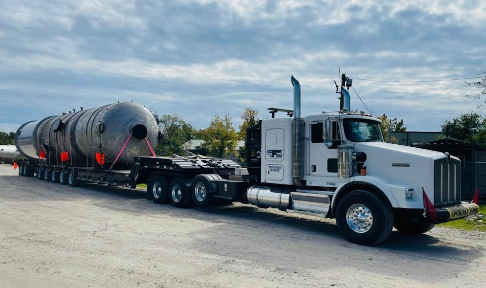 White truck transporting industrial vessel